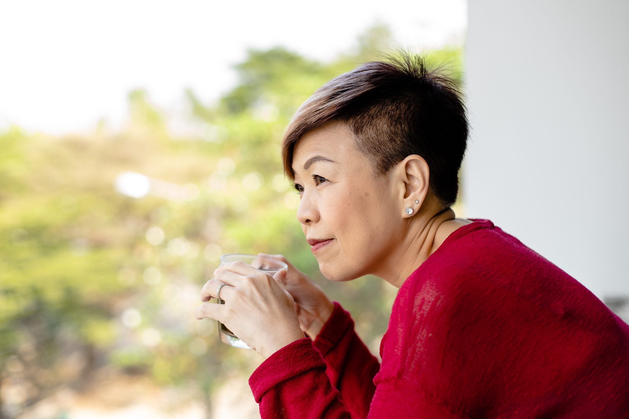 Thai mature woman enjoys her morning with a cup of coffee