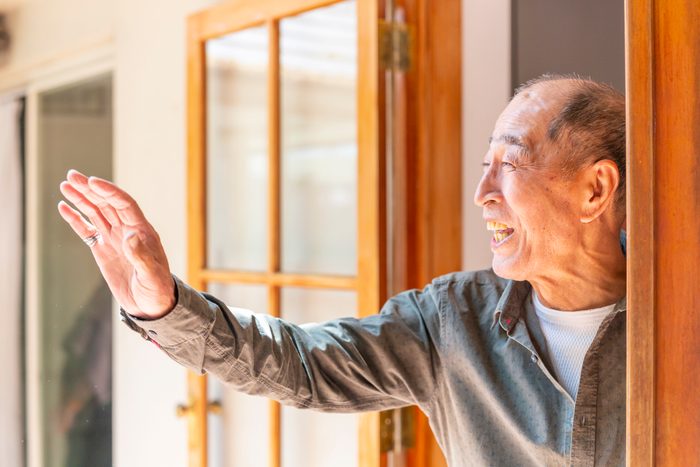 Senior Man Looking Out a Doorway