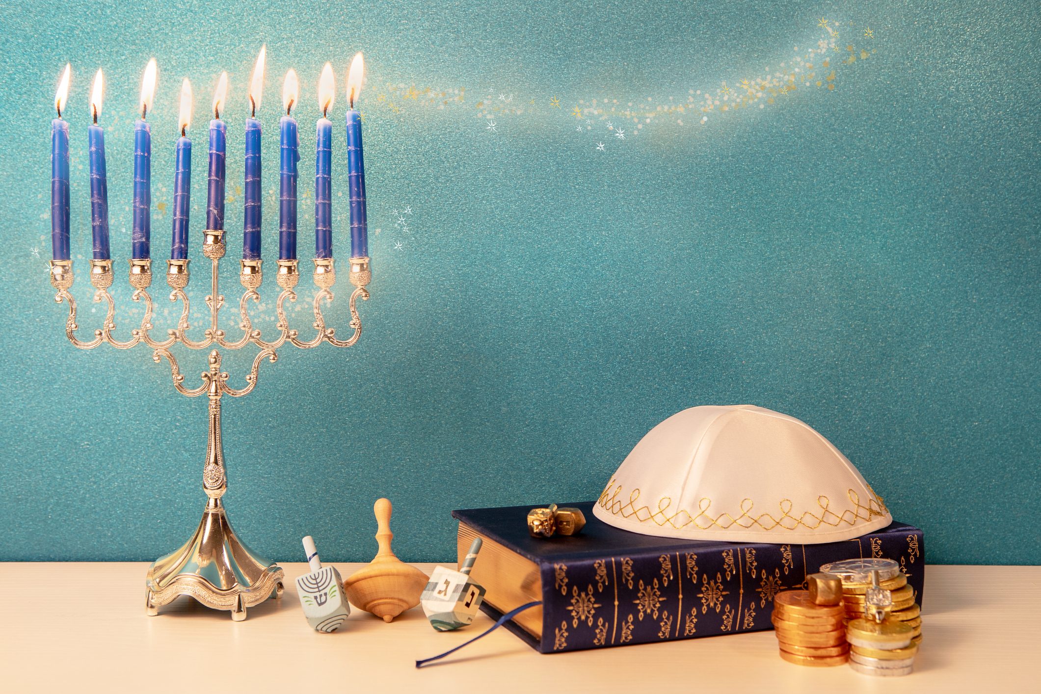 hanukkah still life with traditional chandelier menorah, wooden spinning top toy (dreidel) and other religious attributes