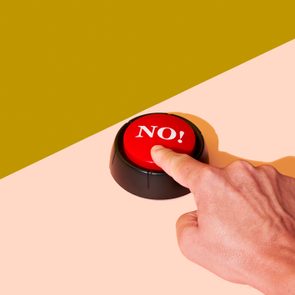 man pushing a red button with the word no