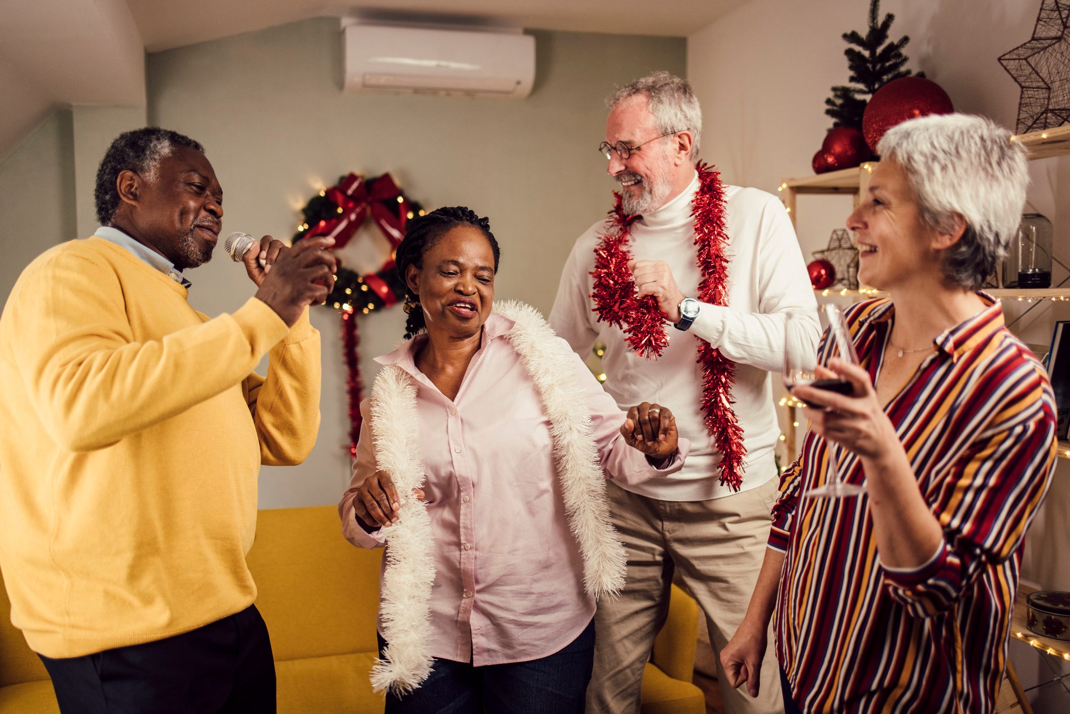 Two senior couples having fun with karaoke on a New Year's Eve