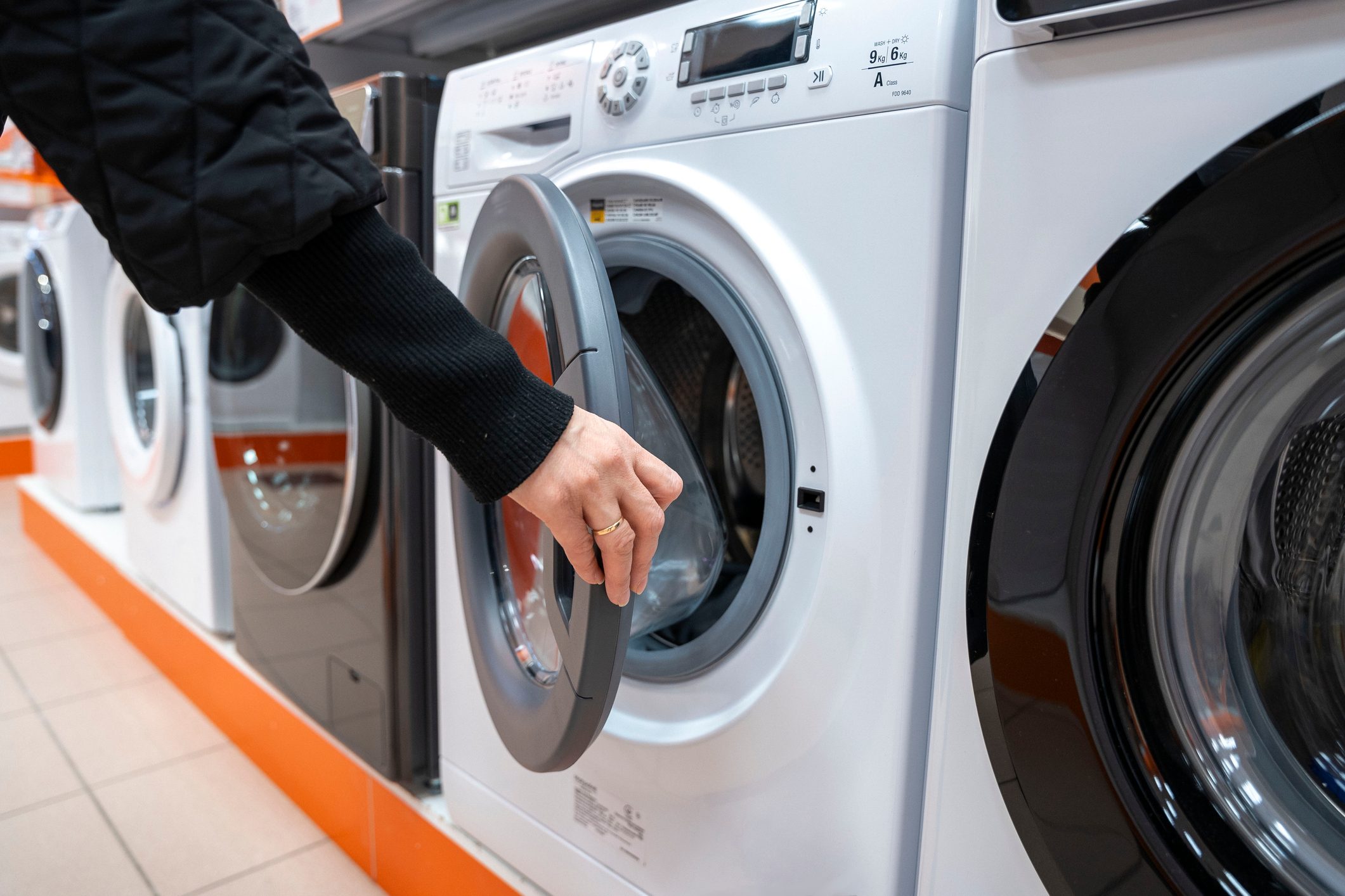 a woman chooses a front-mounted washing machine in a home appliance store