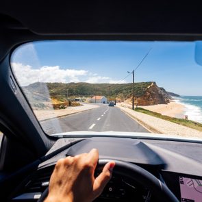 Personal perspective point of view of a man driving along the Atlantic coast in Portugal