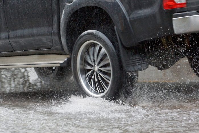 Water Splashed by a car running through a flooded road after heavy rain, blurry movement