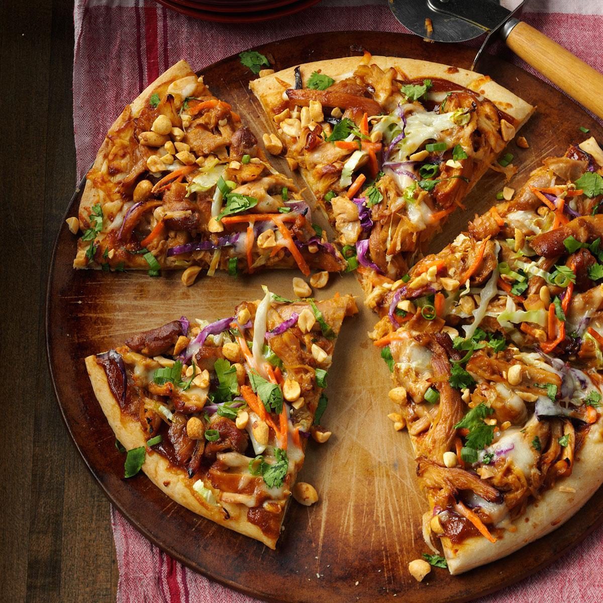 Asian style thai peanut pizza on a wood cutting board