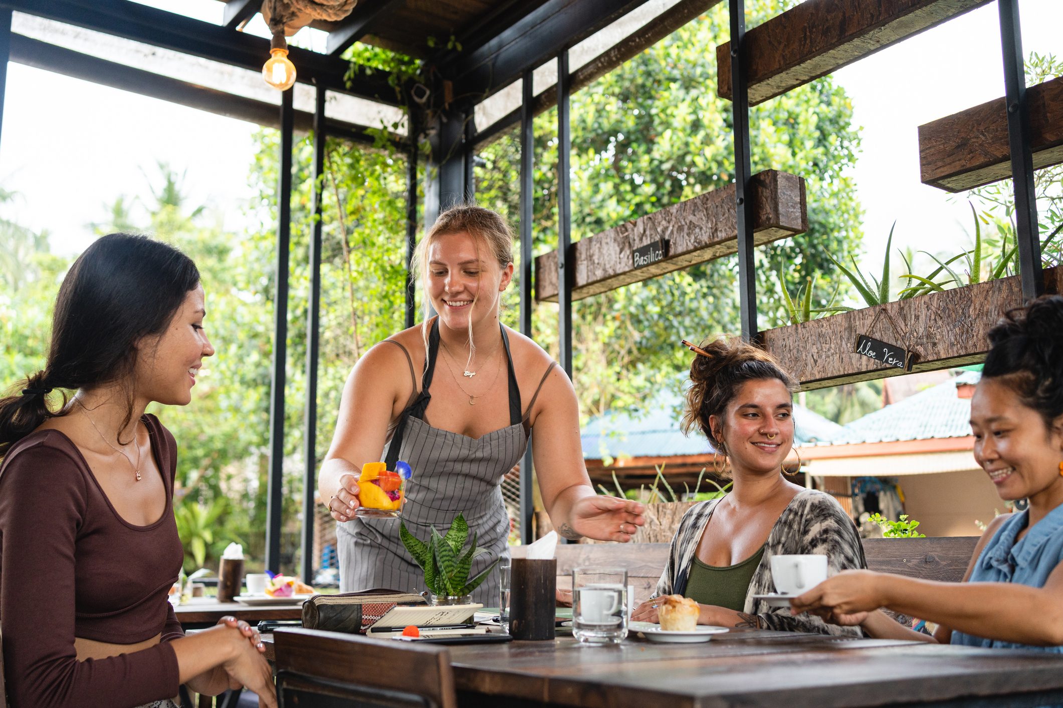 Waitresses serving the female customers, with coffee and fruit cup at the coffee shop