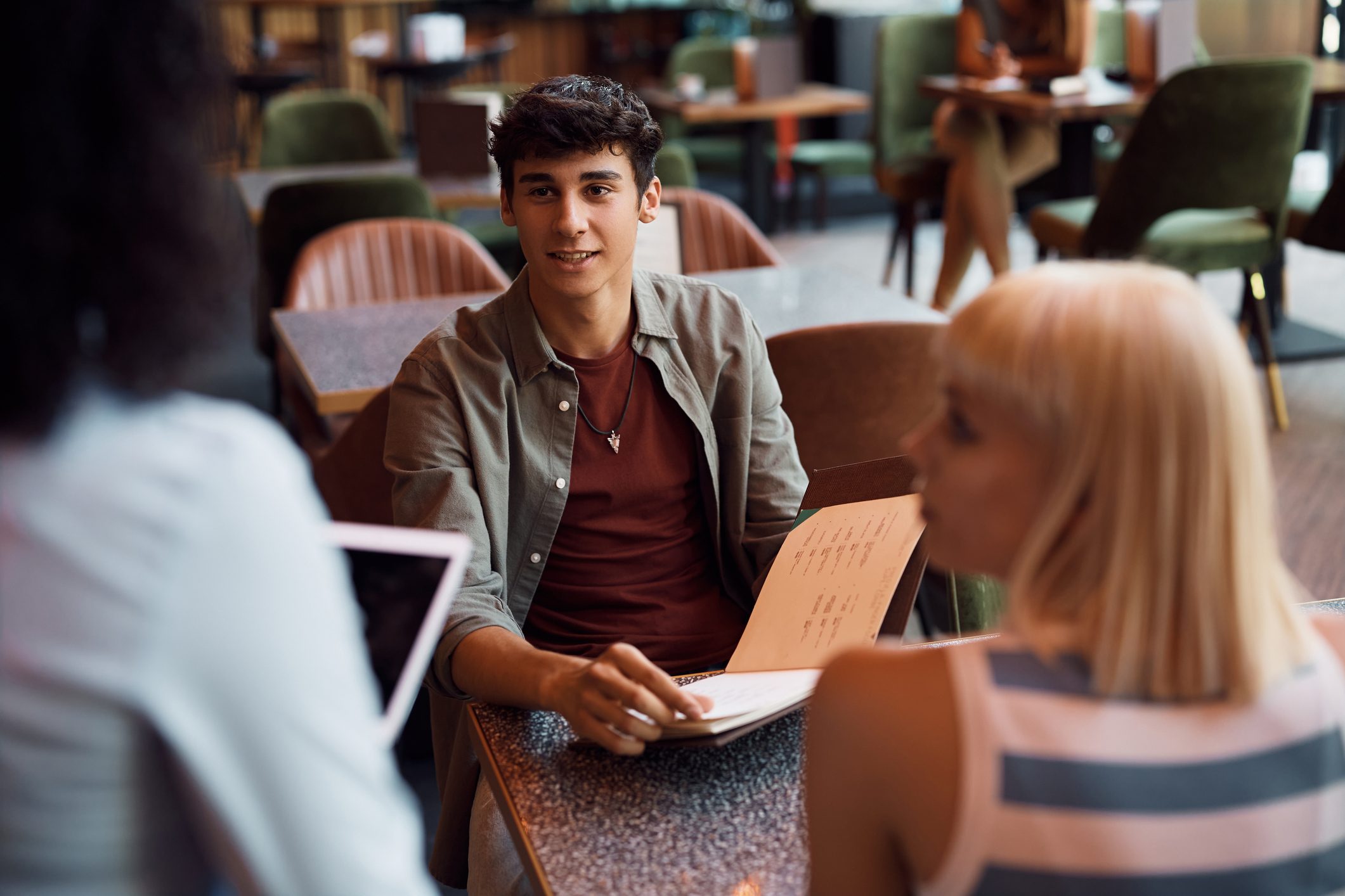 Young couple talking to a waitress in a cafe.