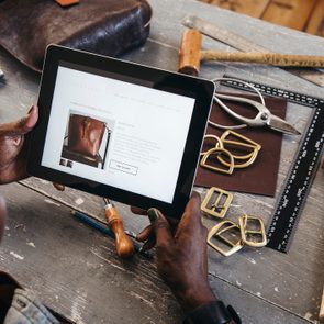 Small Business Owner looks at her website on a digital tablet