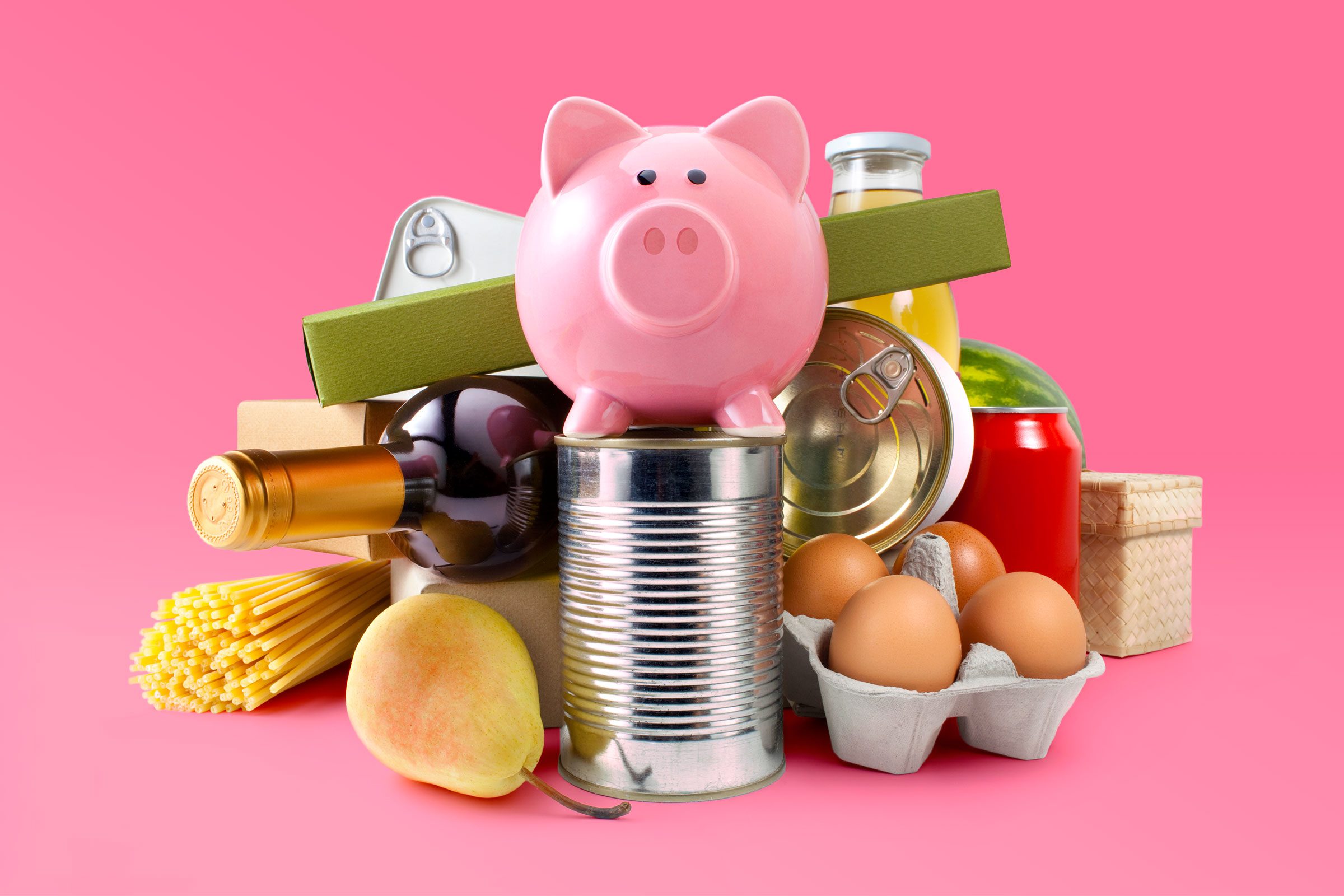 array of Groceries With Piggy Bank on pink background