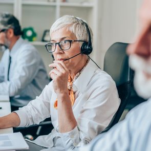 Service Consultant uses computer and headset to answer calls