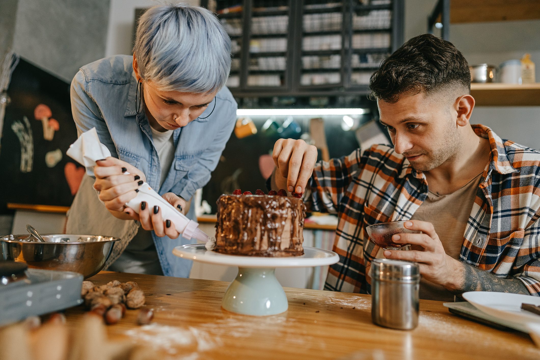 Couple decorating a cake at home