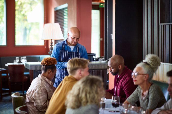 Serious waiter taking orders in restaurant