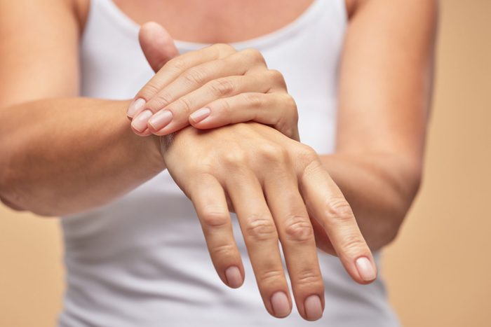 Woman in white t-shirt using hand skin care product