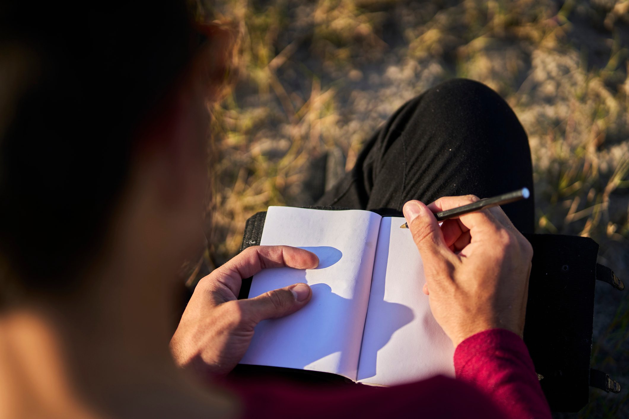 young man writing on the beach