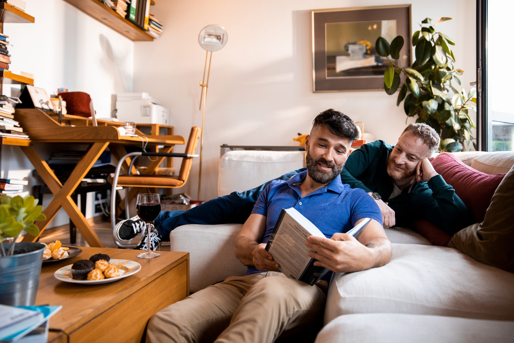 Male couple reading a book together