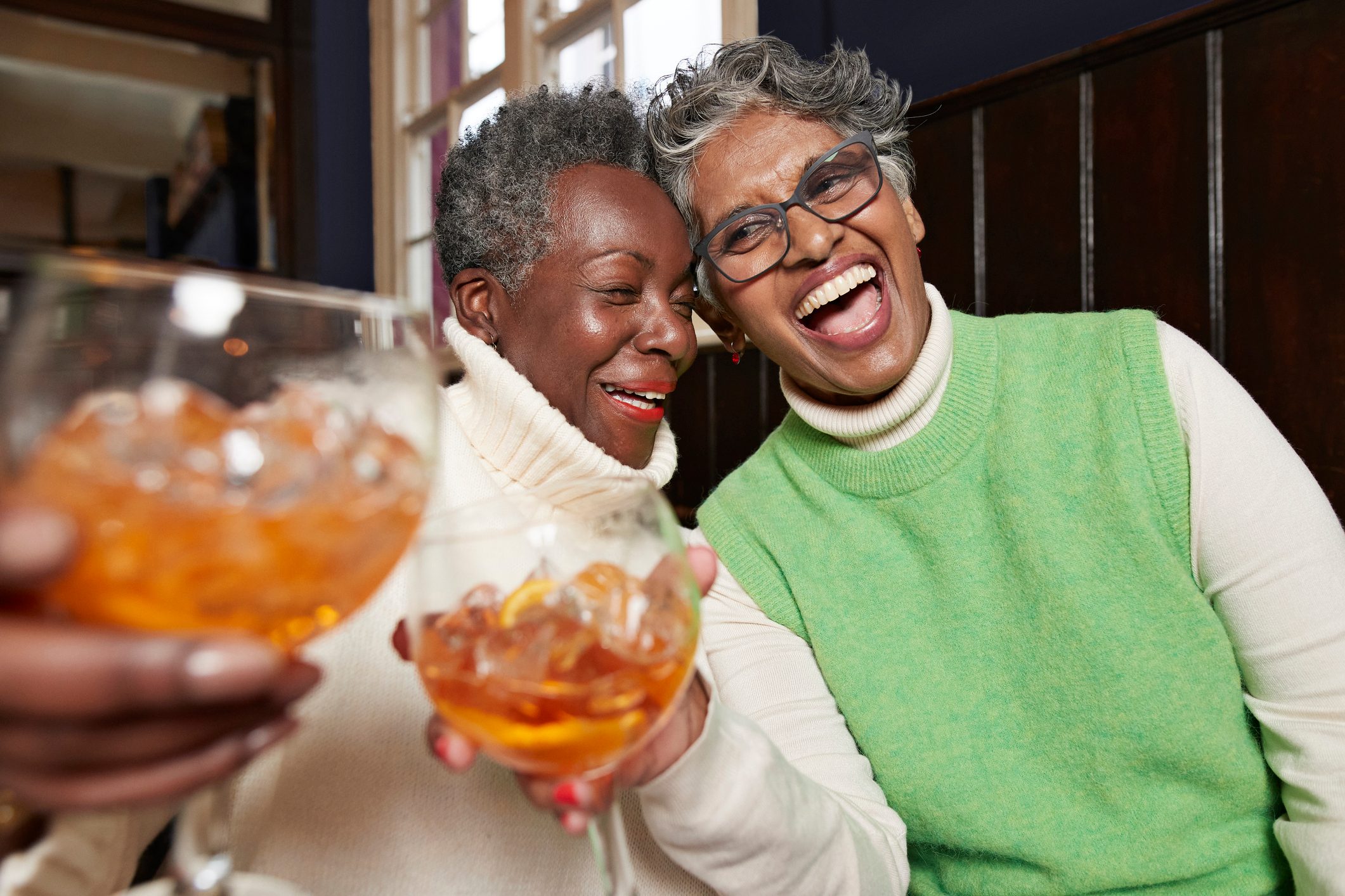 Cheerful senior female friends having fun in restaurant