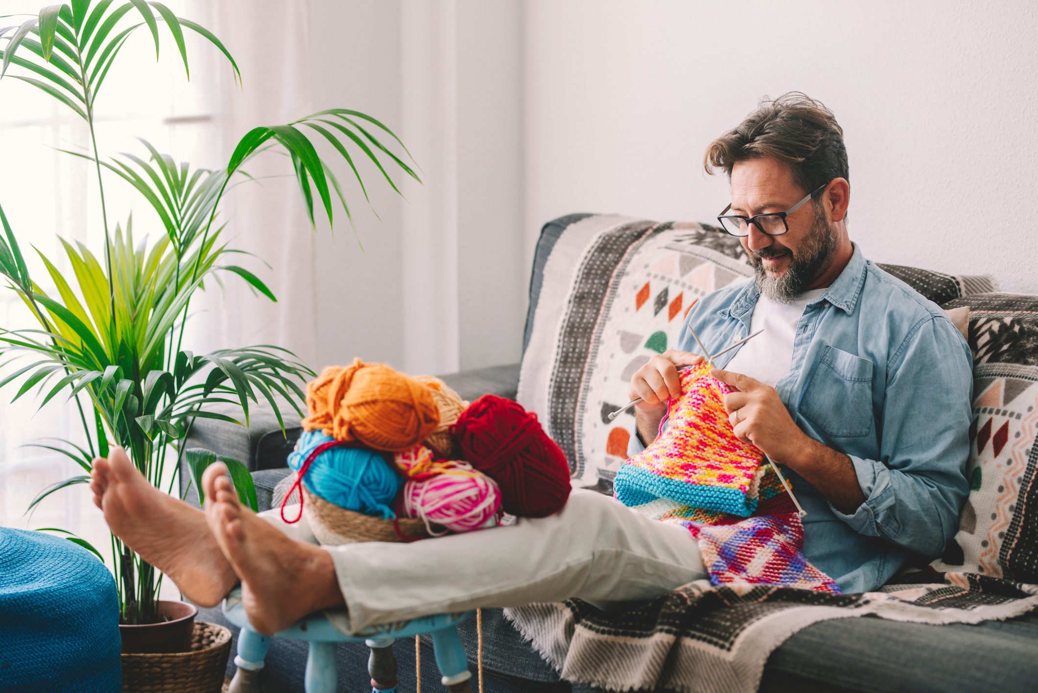 Man Sitting On Sofa At Home