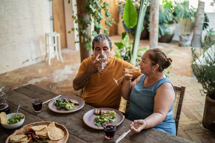 Mature couple drinking white wine and having lunch in the dining room at home