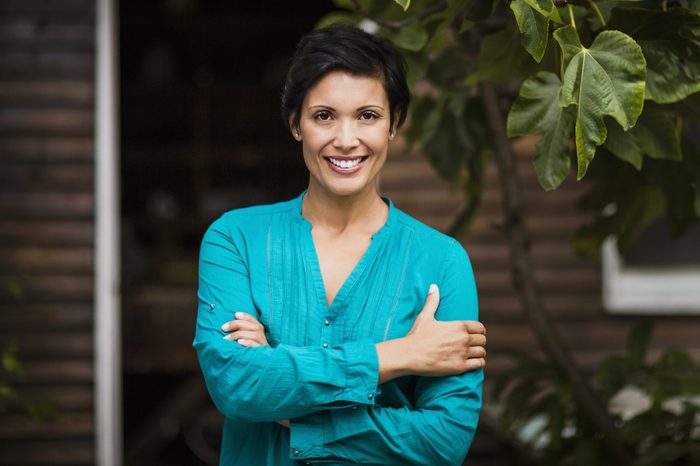 Woman standing arms crossed in yard