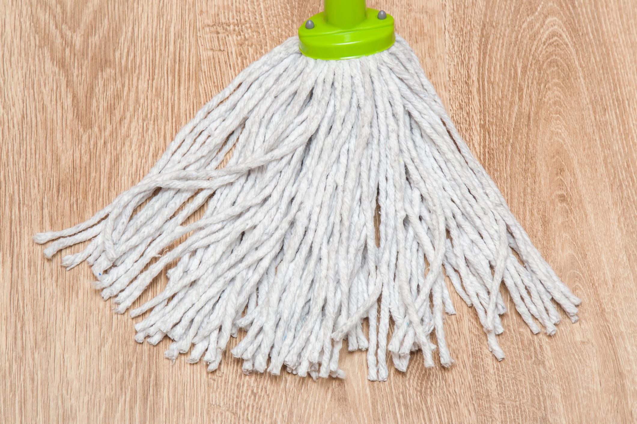 Wooden floors washing with mop in the room.