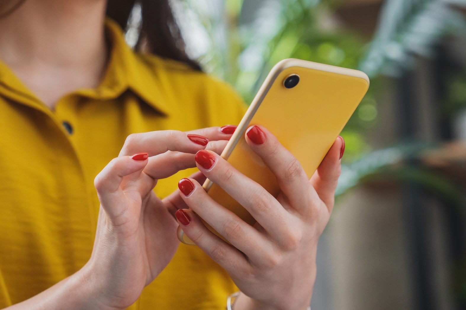 Cropped image of happy girl using smartphone device while chilling at home