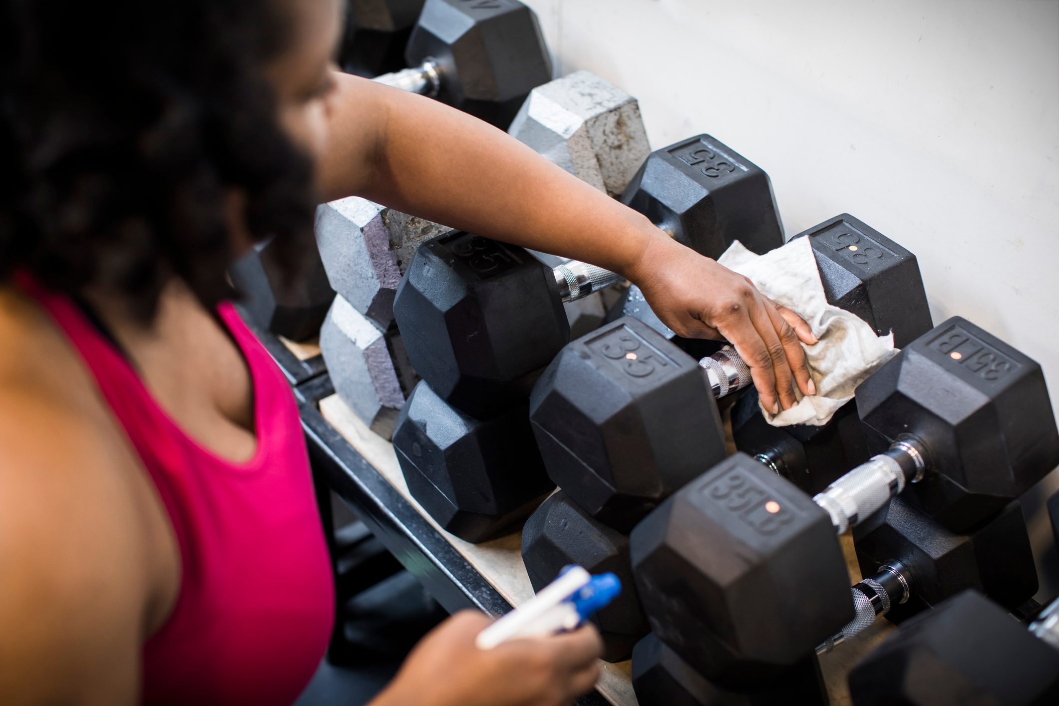 Cleaning gym equipment after workout.