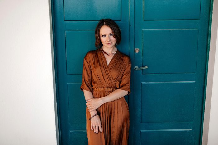 Smiling woman standing against door in resort at Deauville, France