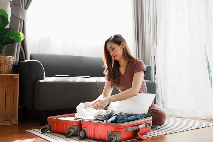 Woman Packing Suitcase At Home
