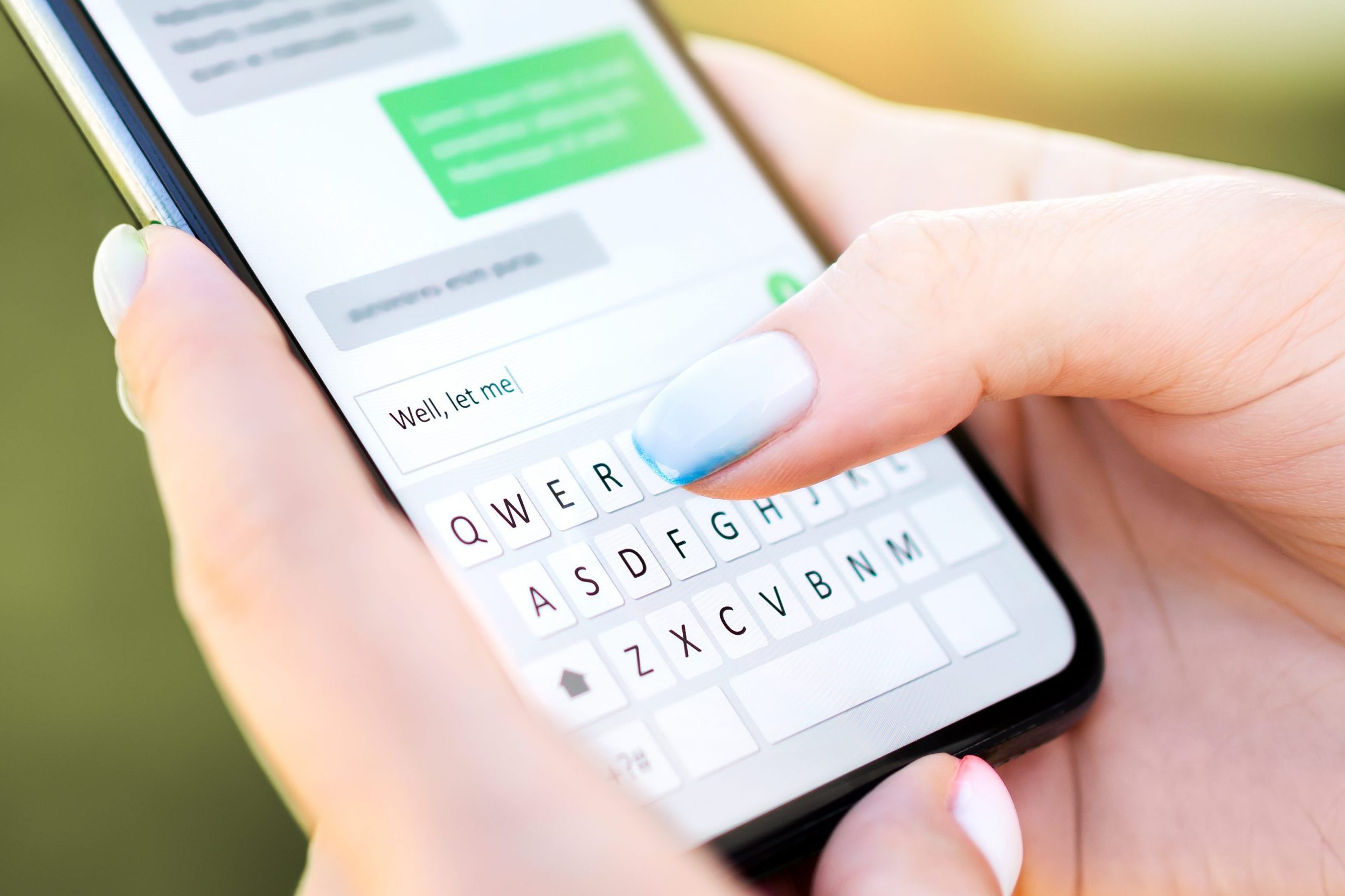 close up of hands sending a text message with a smart phone