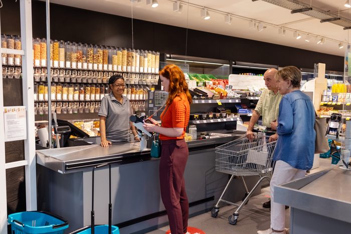 People at supermarket checkout counter