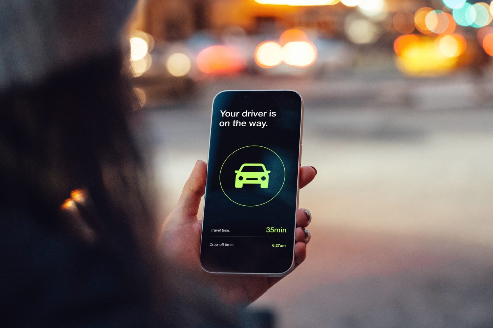 Young woman ordering a taxi ride with mobile app on smart phone