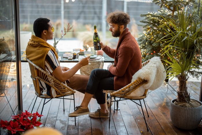 Two male friends celebrating winter holidays at backyard