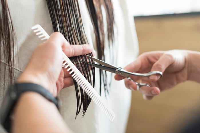 Male hairdresser cutting a female client's hair