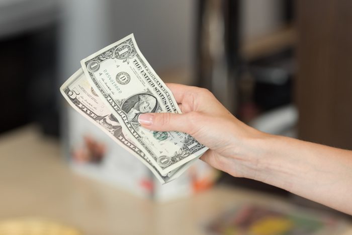 Woman pays cash for the breakfast in the cafe.