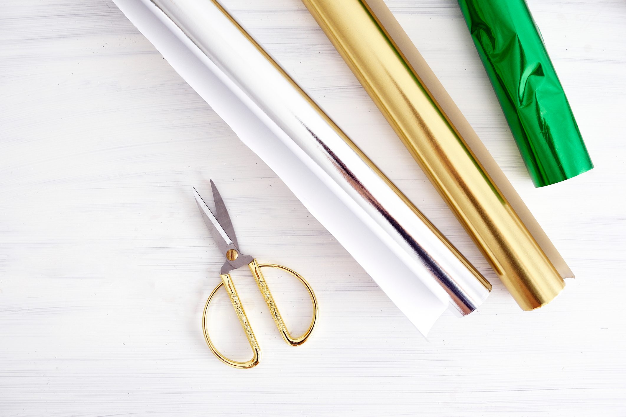 Christmas gift wrapping materials on a white table