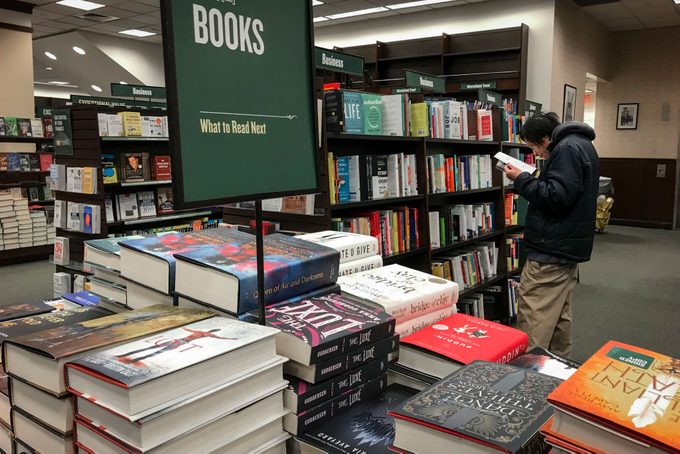 A shopper looks through a book at a Barnes & Noble bookstore