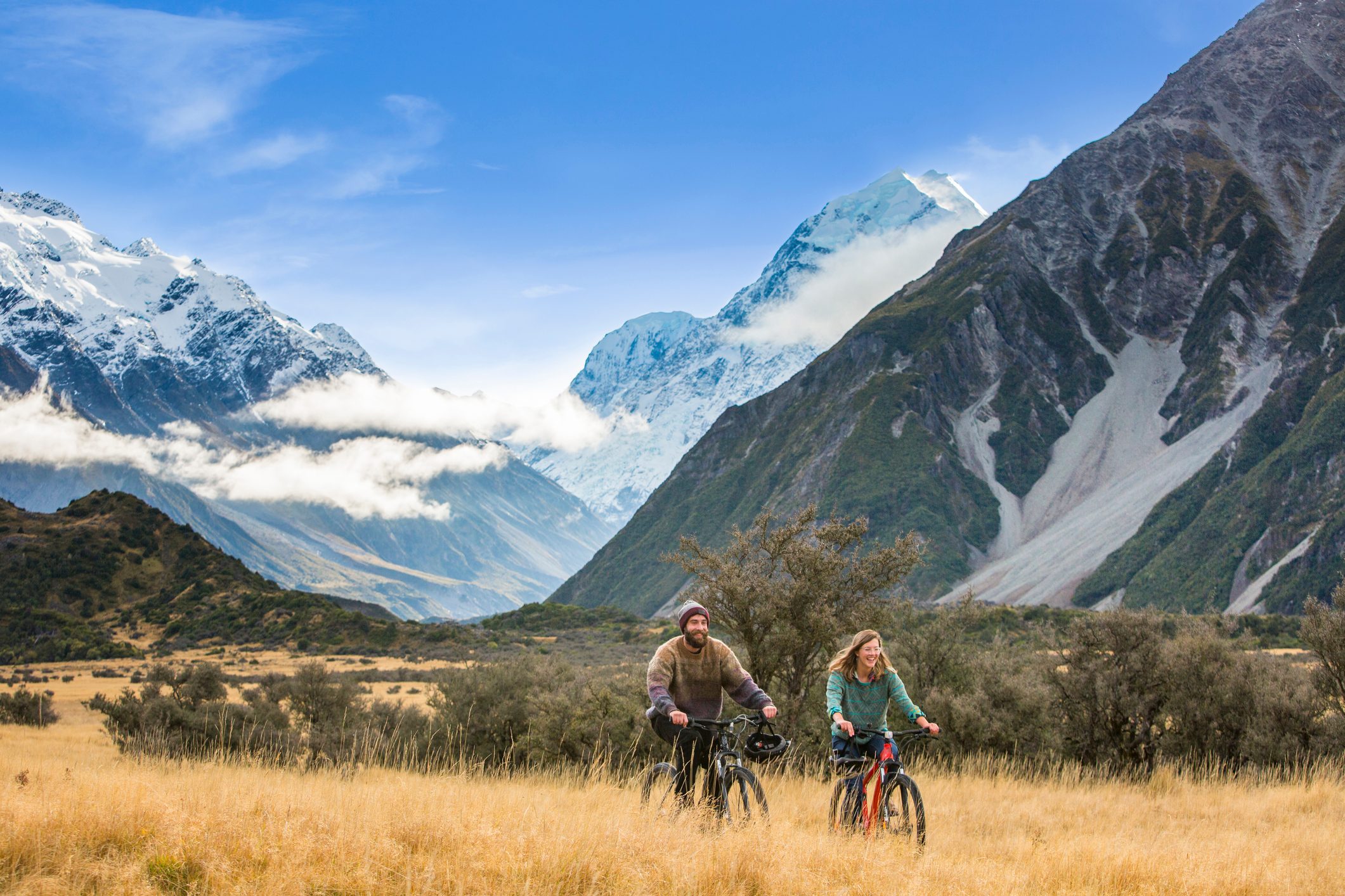 Friends ride bikes through the Mount Cook National Park.