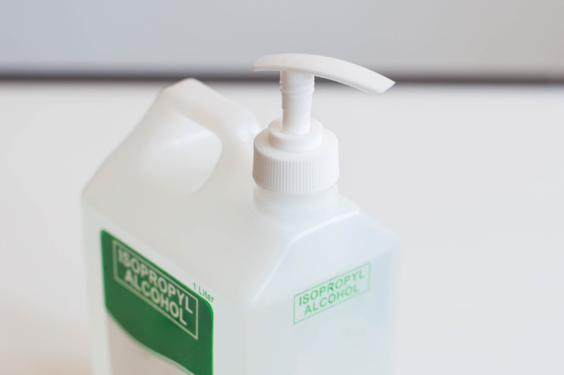 A still life of isopropyl alcohol on a plastic dispenser