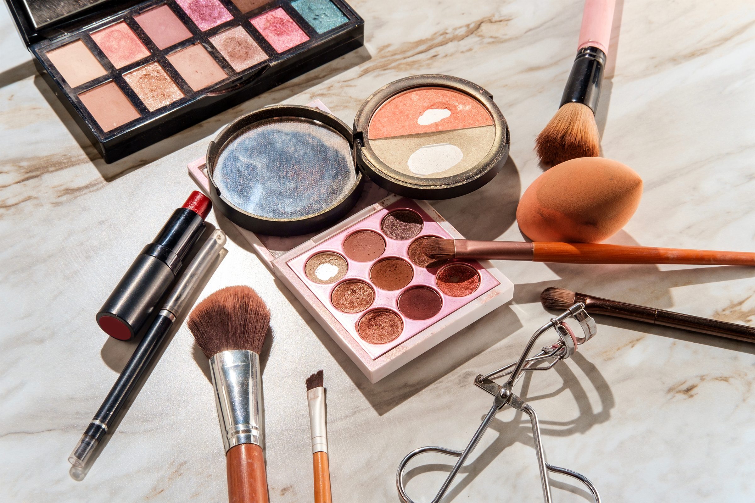 Used makeup and beauty cosmetics products on a marble table