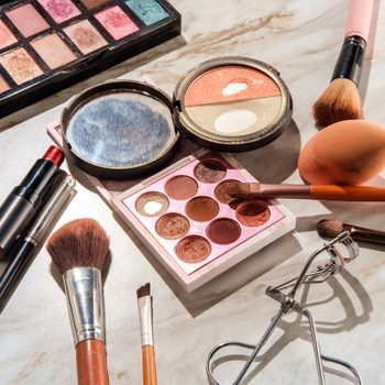 Used makeup and beauty cosmetics products on a marble table