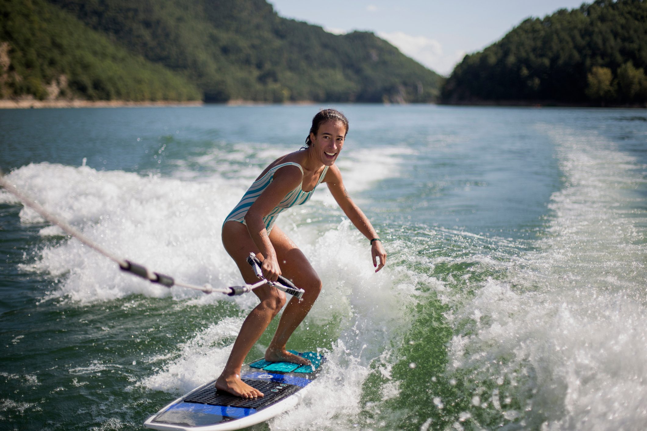 Girl Surfing In Lake Against Mountains