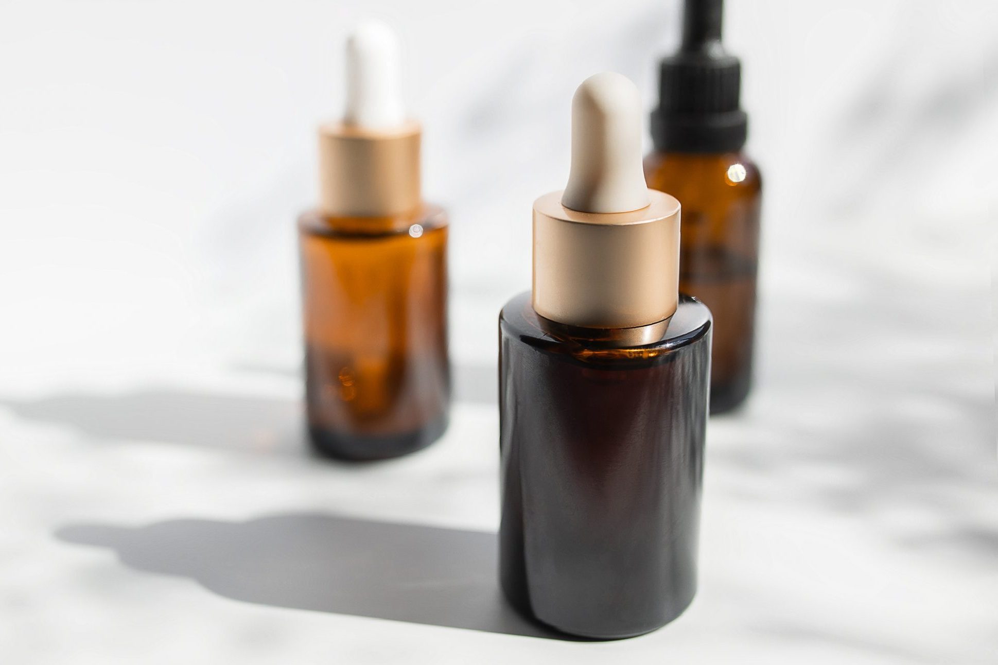 Brown glass with a dropper. Bottle mockup cosmetic oil dropper on a grey background and shadows. Copy space