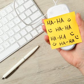 Woman holding computer mouse with sticky note