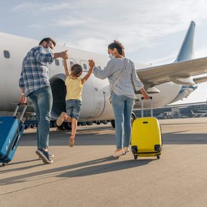 Happy family in masks enjoying travel together