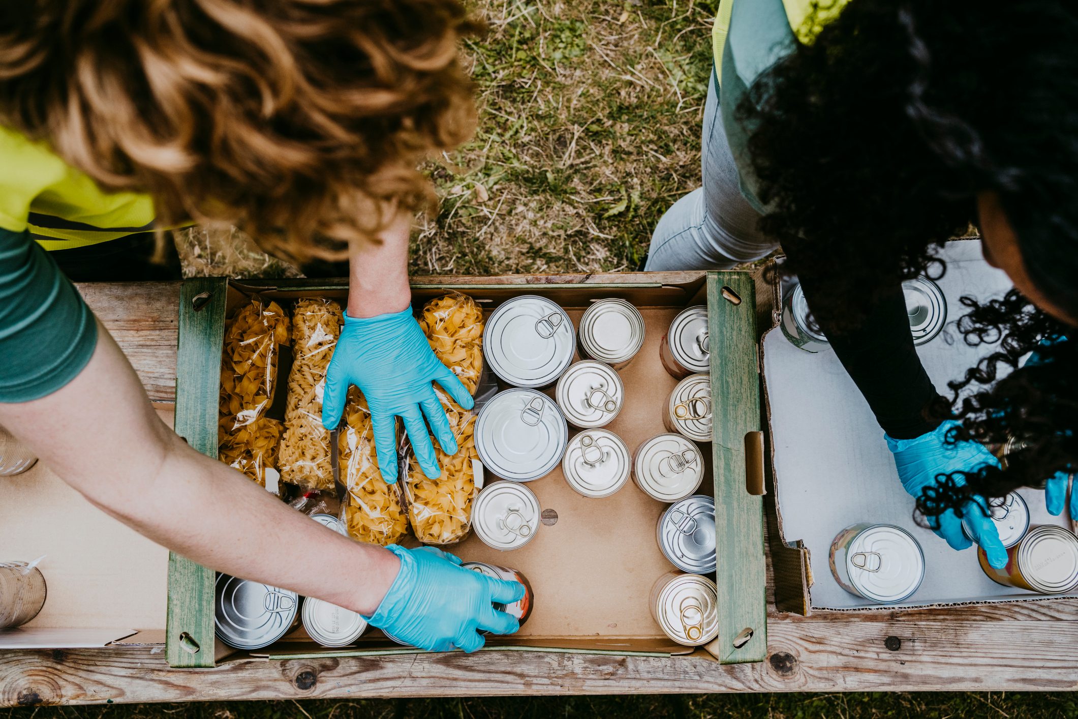 Male and female friends arranging food in cardboard boxes