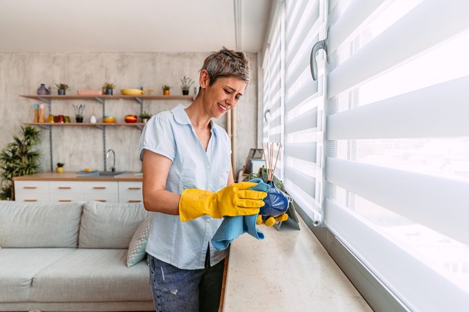 Senior Woman Cleaning The Dust Off Of Scented Sticks Holder