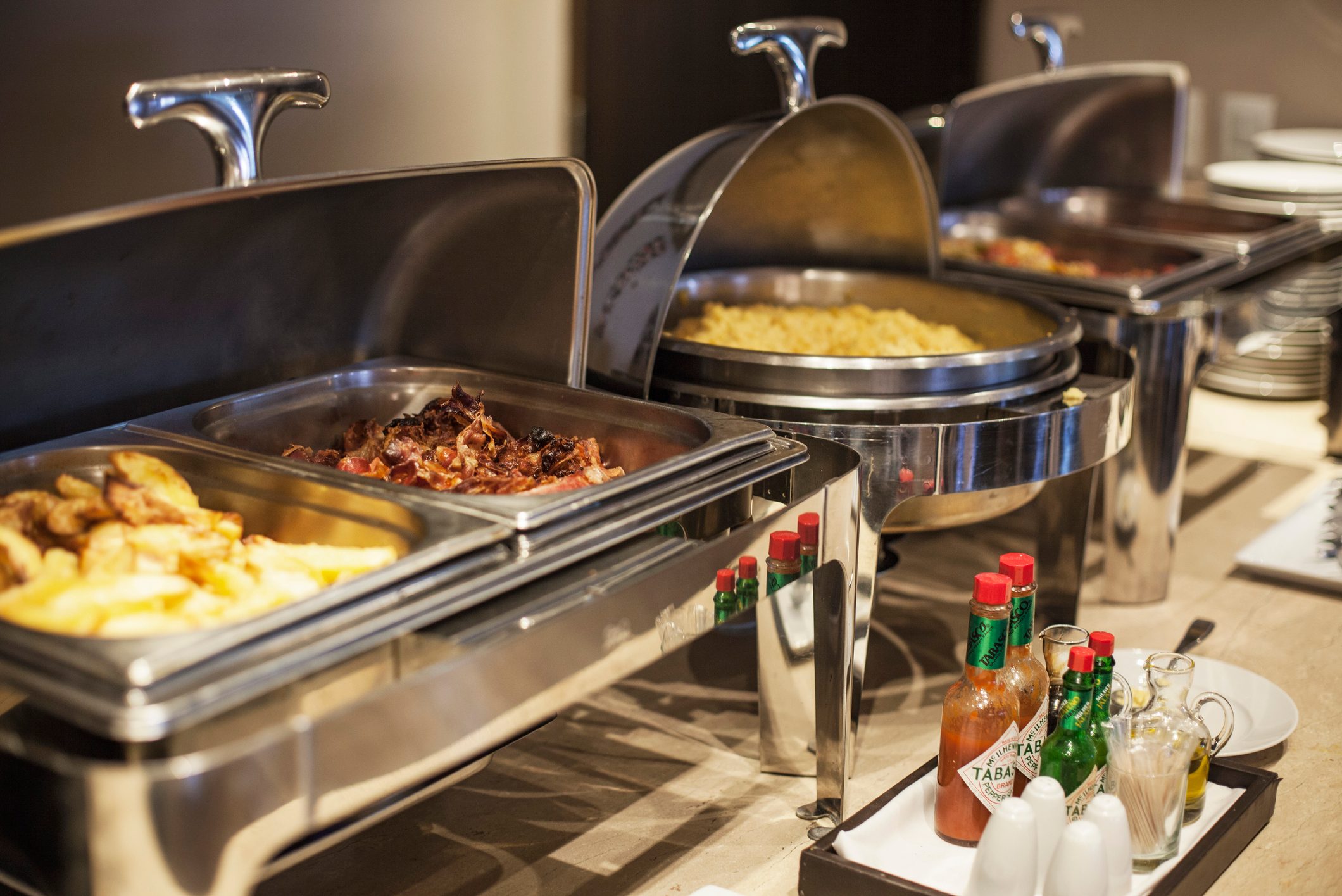 Prepared food in warming dishes on buffet