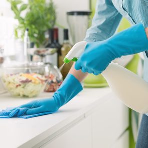 Woman cleaning with a spray detergent