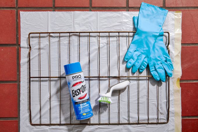 oven rack and cleaning supplies set up in an outdoor area