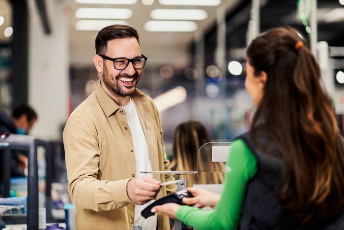 man making a joke to the cashier while cashing out at a grocery store